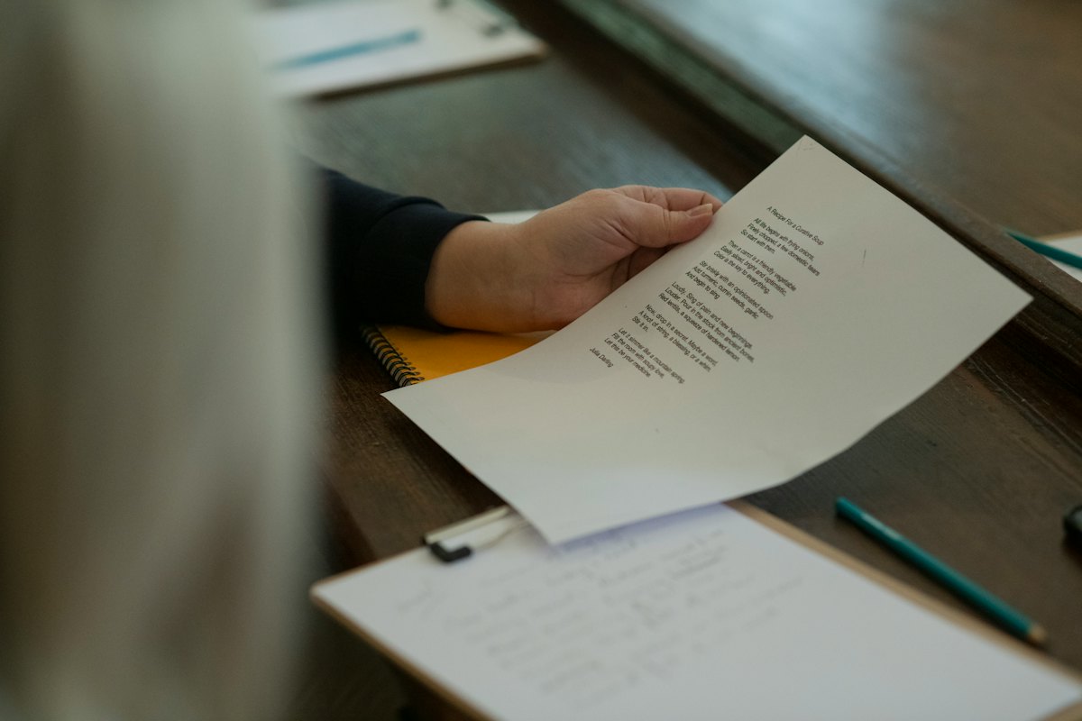 A hand holding a sheet of printed paper