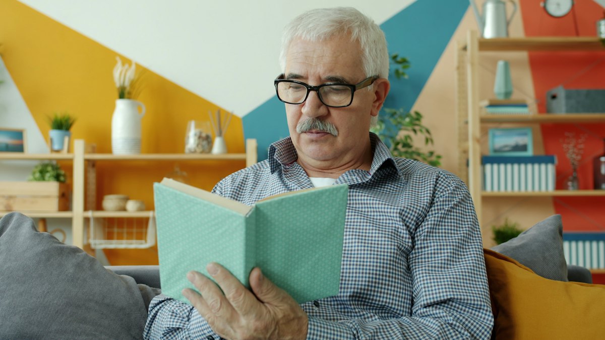 An older man in glasses sitting at a table