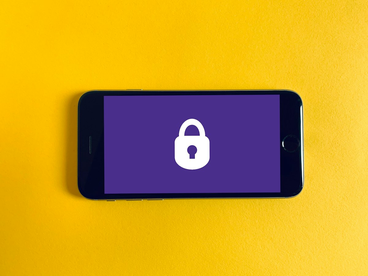 A phone showing a padlock icon on a yellow background